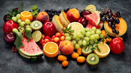 Assorted fresh fruits on dark background.