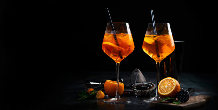 Aperol spritz cocktail served on dark background.
