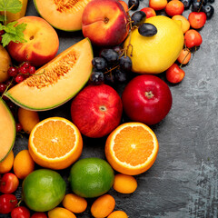 Assorted fresh fruits on dark background.