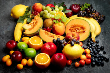 Assorted fresh fruits on dark background.