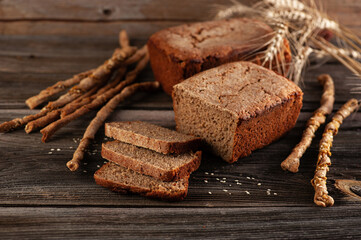 Rye homemade bread with bread sticks on a wooden old table