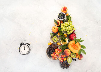 Christmas tree made of fruits on light gray background.