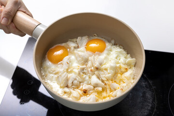 homemade sunny side up fried eggs with crabmeat in pan on oven, gourmet food recipe, good work from home lunch idea, shallow depth of field