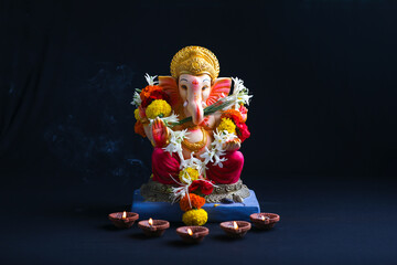 Decorative Lord ganesha sclupture on dark background. - obrazy, fototapety, plakaty