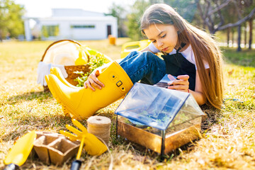 beautiful schoolgirl teenager spending time outdoors in garden wear yellow rubber shoes boots...