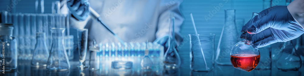Canvas Prints scientist holding flask with lab glassware in chemical laboratory background