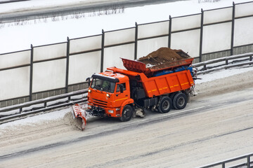 Snowplows removing the snow the highway on a cold snowy winter day.