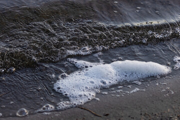 white foam of a small wave on a beach