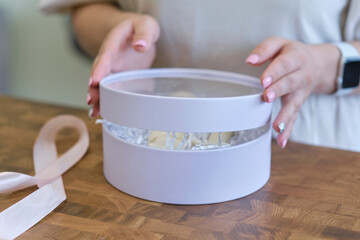 woman entrepreneur packs the order in a beautiful box, perfect service for customers.