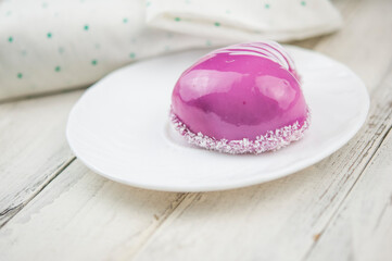 a cup and heart-shaped cake on a white wooden background