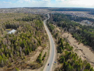 Fototapeta na wymiar Aerial view of the road between forests in spring (Kirov, Russia)