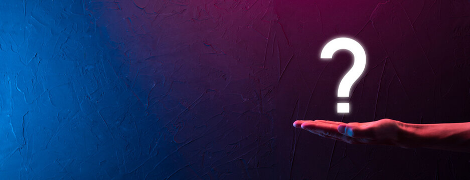 Male hand holding question mark icon on neon red,blue,purple background.Banner with copy space. Place for text.