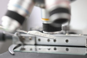 Fototapeta na wymiar Study of white powder in a laboratory under microscope closeup