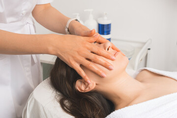 Fototapeta na wymiar Close up photo of young woman having facial massage in beauty salon