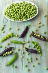 Peeled green peas in a white bowl. Kitchen scene. Shallow depth of field.