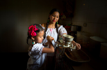 mom and daughter grinding coffee with traditional style