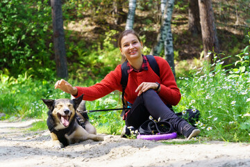 A girl is playing with her dog in the forest. Playing with her funny friend. Summer, Early autumn