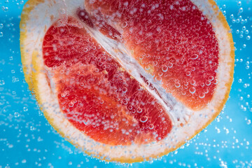 Grapefruit close up macro, under water, for juice. Ripe juicy fruit in water