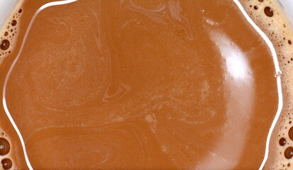 Chocolate milk puddle with bubbles. Chocolate milk texture, macro shut.