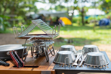 Outdoor kitchen equipment Stainless steel kettle, portable gas stove, bowl  with outdoors table set in camping area