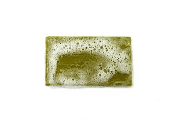 Hand made Olive Soap bar with foam isolated on white background. Wet bar of soap.