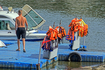 Life jackets hang on the pier of pleasure boats