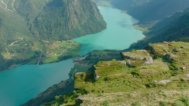 Klovane Peak Overlooking Oldevatn Camping By The Lake Oldevatn Surrounded By Steep Mountains In Olden, Norway. aerial pullback (tilt-up)