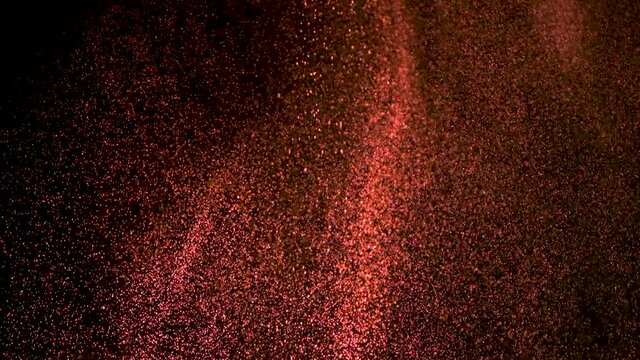 The fall of red particles on the black background. slow motion