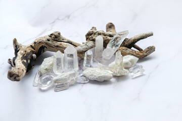 Clear quartz minerals and tree branch on marble background. Magic gemstones crystals for healing spiritual practice, relaxation and meditation. Esoteric life balancr concept