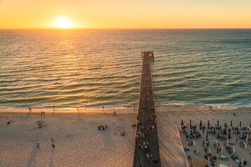 Glenelg beach with people walking along the jetty at sunset viewed from above, South Australia
