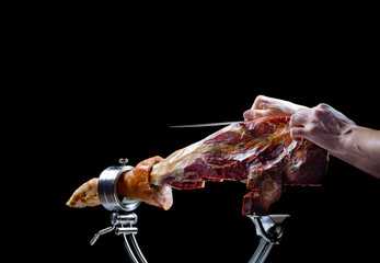 Corte jamón jamón ibérico  sobre fondo negro. Iberian ham ham slice on black background.