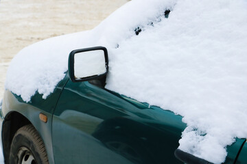 Car in the snow. Bad weather in severe weather. Inoperative transport in the courtyard of the house.