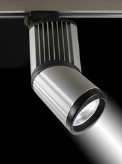 Foco de luz plateado sobre un riel. Silver light bulb on a rail.