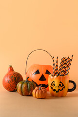 Halloween fun party decorations, candy bowl, pumpkins, sweets, mug with drinking straw on orange...