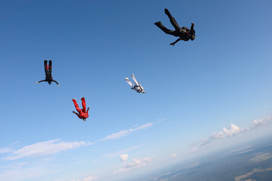 Skydiving.  A team of skydivers is in the sky.