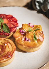 Fototapeta na wymiar Homemade Tart desserts decorated with fresh strawberry, peach apricot, mint
