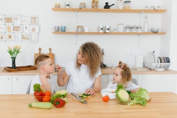 Family in a kitchen. Beautiful mother with children. Lady in white blouse.