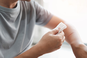 Asia man use medical cotton swab for cleaning and disinfection of wounds Cat scratch in First aid...