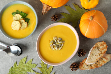 Concept of tasty food with pumpkin soup on gray textured table