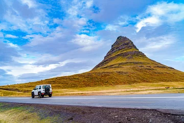 Papier Peint photo autocollant Kirkjufell A jeep drove by the iconic Kirkjufell mountain in a gloomy autumn afternoon -- Iceland