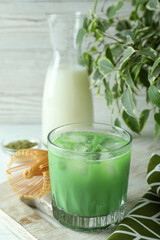 Matcha latte and accessories for making on white wooden table