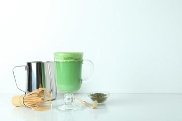 Matcha latte and accessories for making on white table