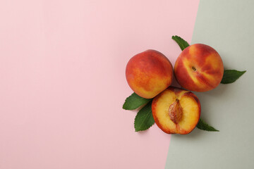 Ripe peach fruits with leaves on two tone background