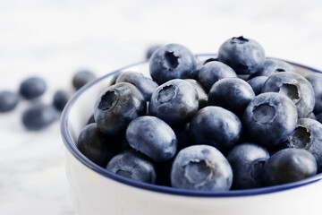 composition of ripe blueberries on a textured marble background