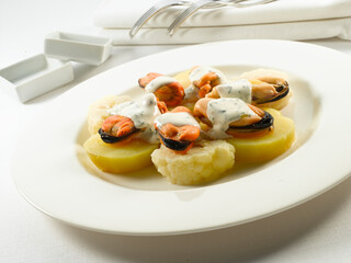 Mejillones con patatas y salsa de queso. Mussels with potatoes and cheese sauce.