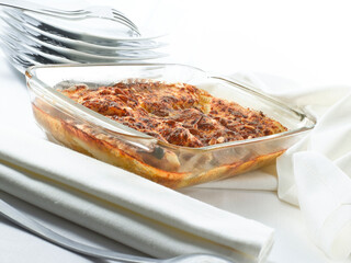 Pollo gratinado con bechamel y queso parmesano en fuente de horno. Chicken gratin with béchamel and Parmesan cheese in a baking dish.