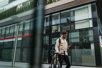 Man using phone while going to work with his bike