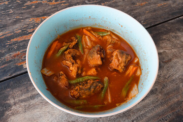 A tangy and flavorful sour fish curry served in a bowl, a staple dish in coastal cuisine.

