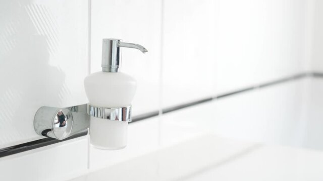 Woman hand washing with liquid soap over bathroom sink, close-up of female hands using antibacterial sanitizer, coronavirus COVID-19 prevention, hygiene
