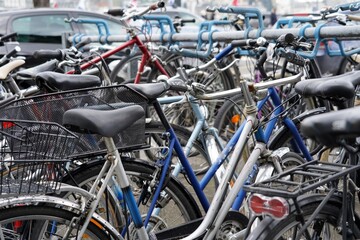 Bicycles parked on a busy street with cars in Lucerne, Switzerland. Background picture to mobility or alternative transport in cities.  - obrazy, fototapety, plakaty